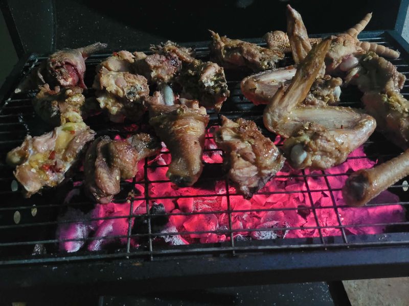 Meat grilling over coffee wood charcoal embers